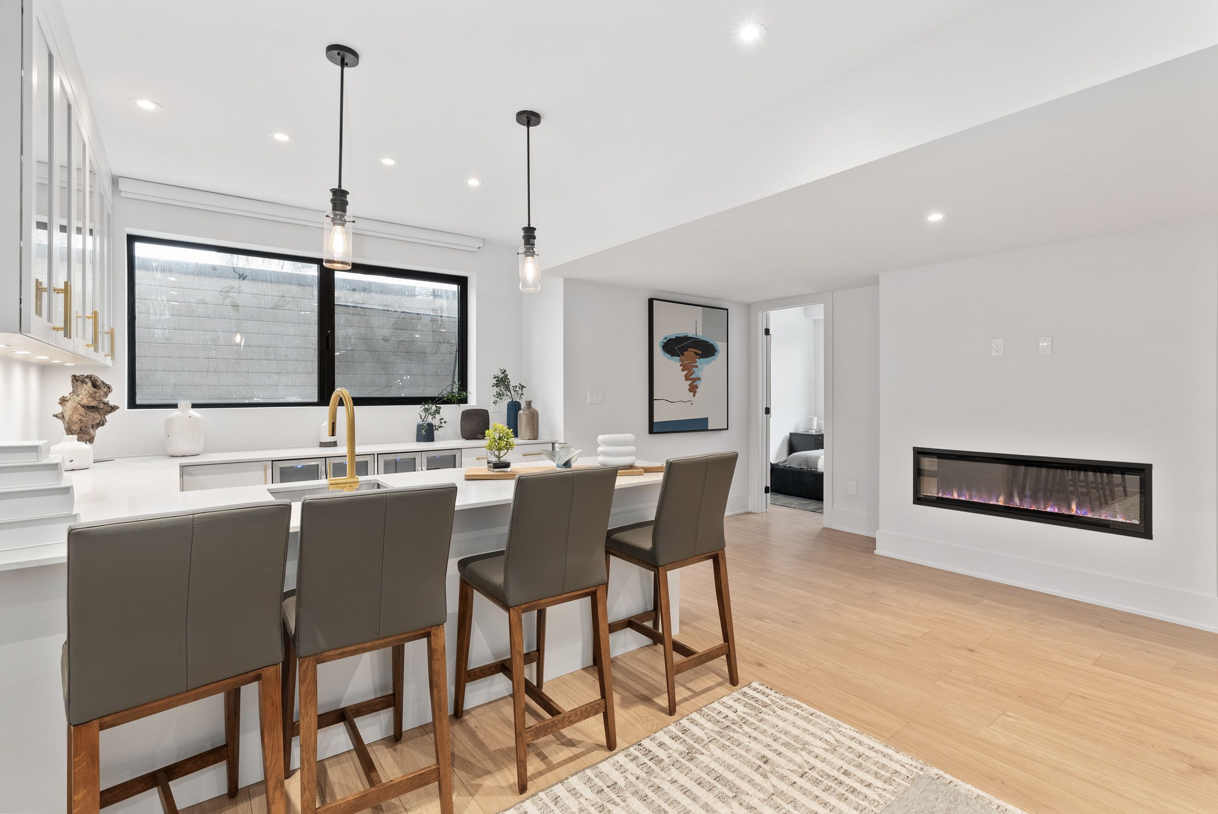Lower-level living area with a kitchenette and linear fireplace.